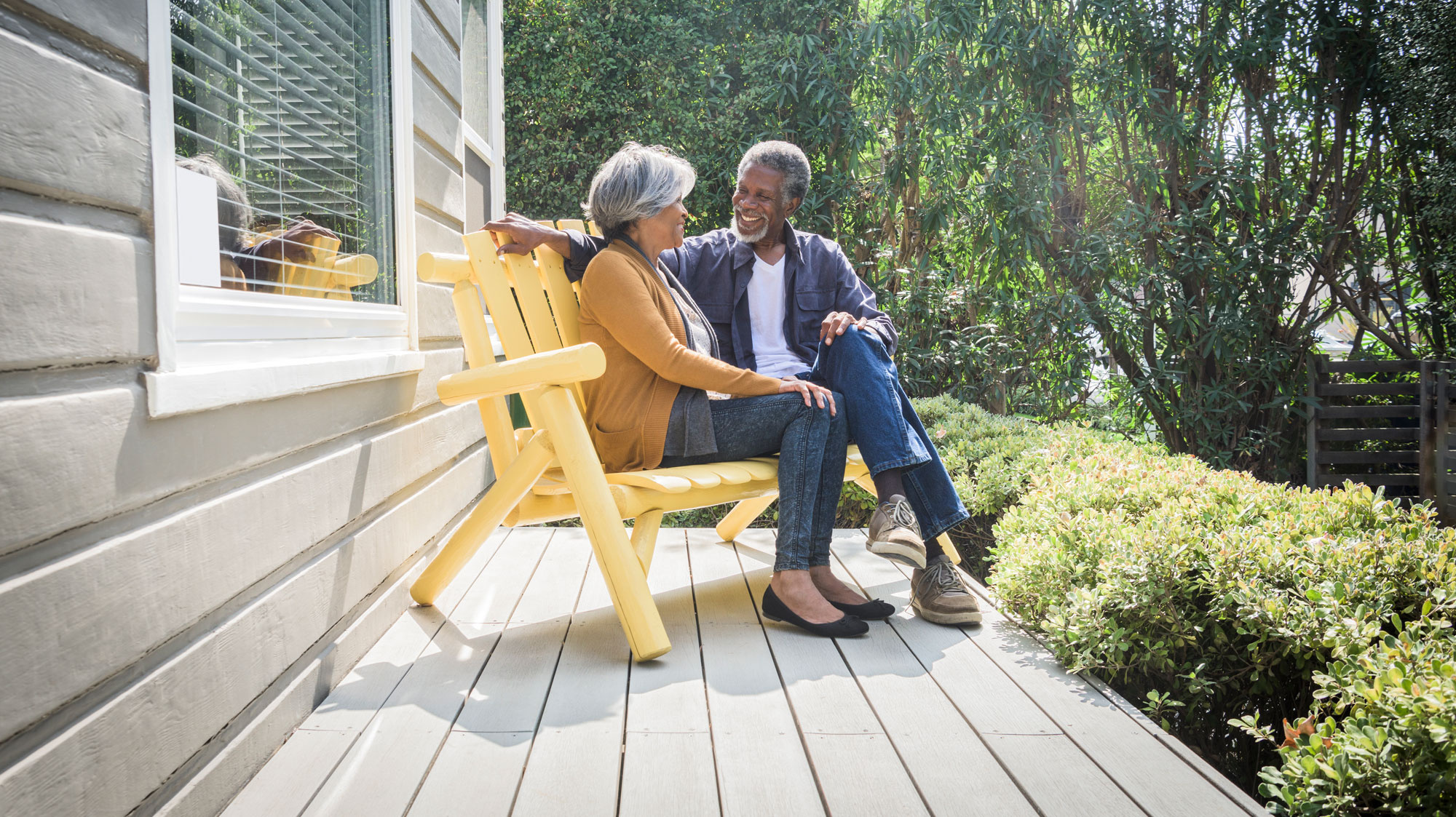 Elderly couple sitting on bench on a porch