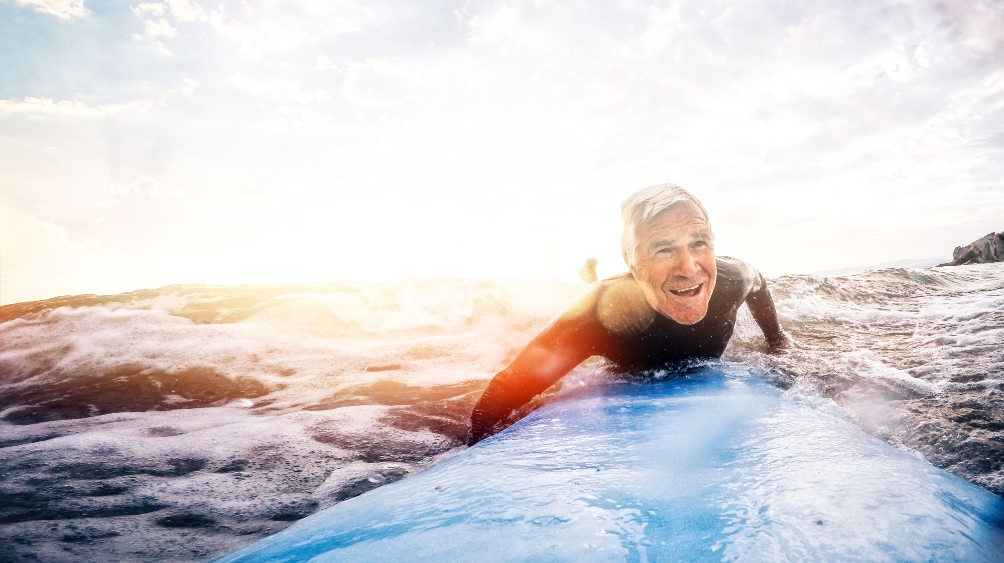 Older man smiling and surfing