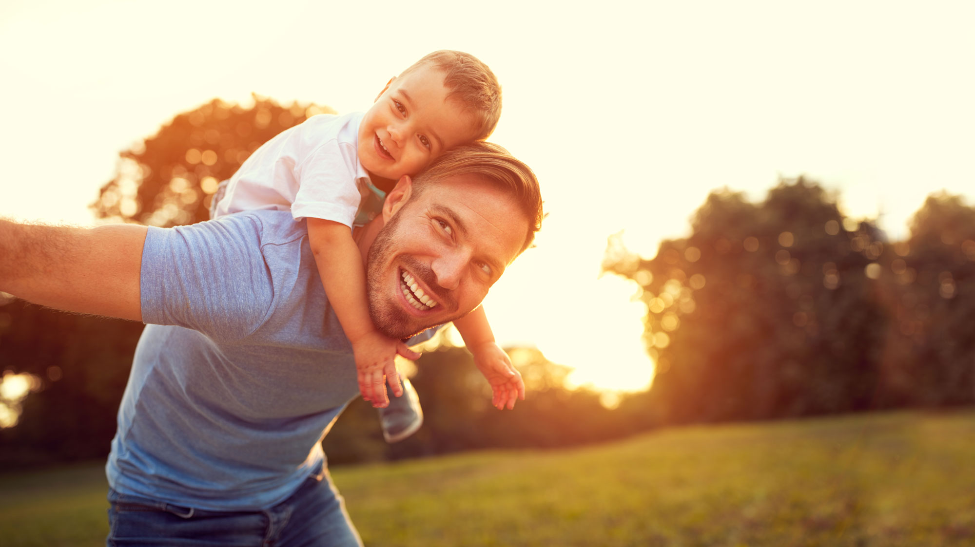 man with child on his back