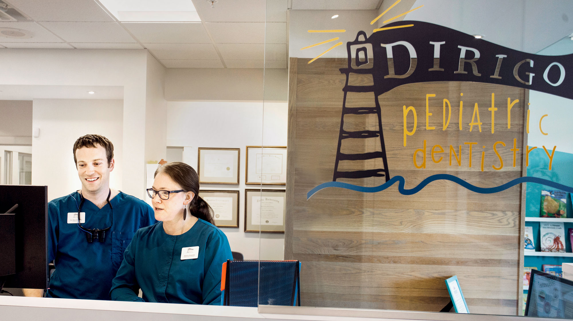 Photo of two people working at front desk of dentist office