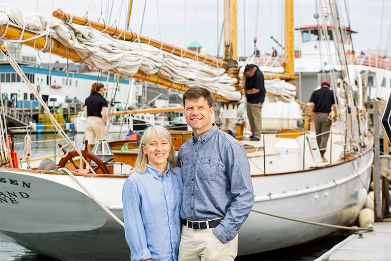 Portland Schooner Company owners in front of sailboat